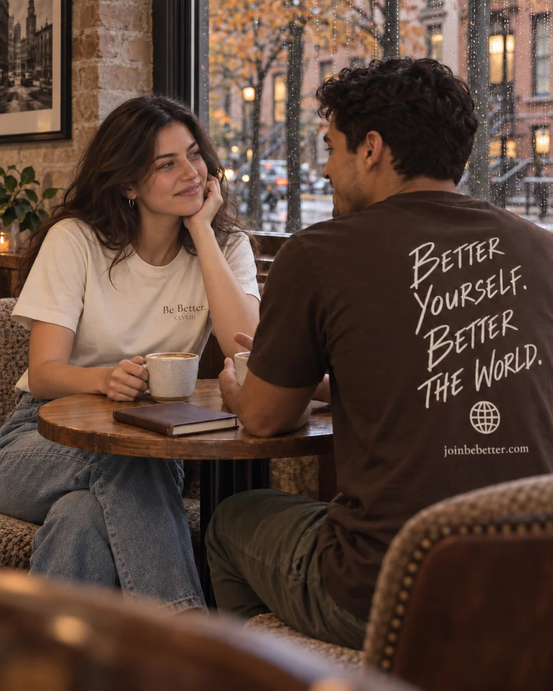 Friends wearing Be Better T-shirts at a cafe
